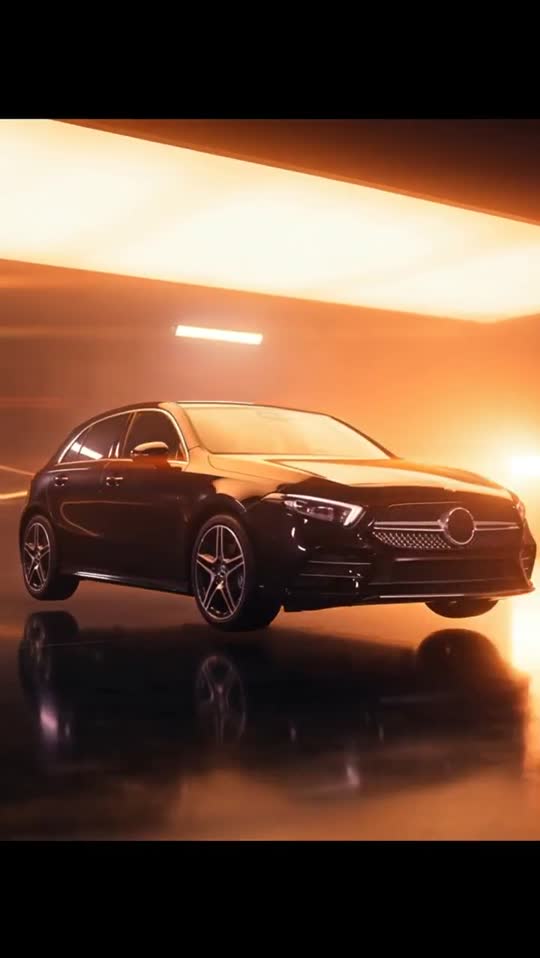 Close view of a black Mercedes lit by orange streaks